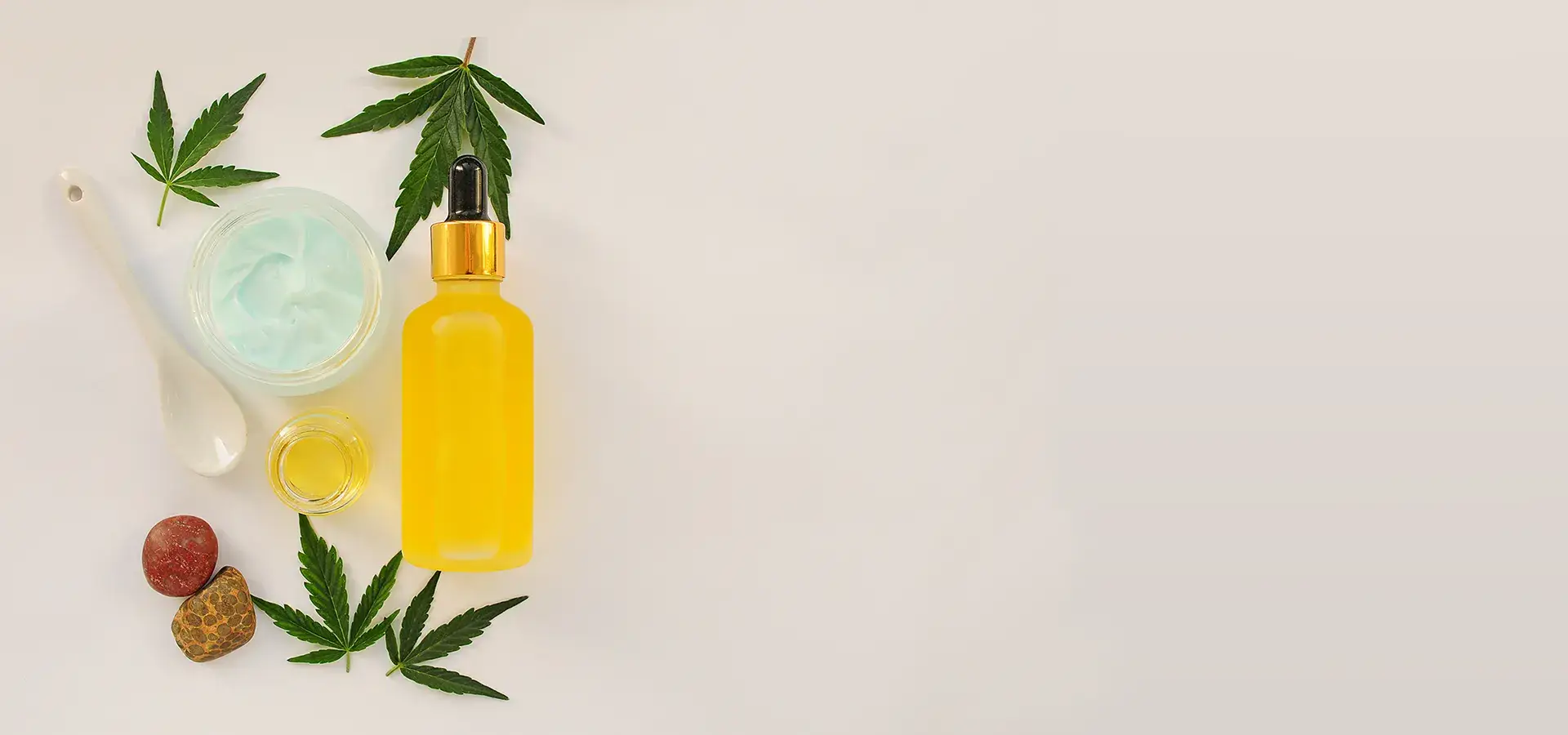 Flacon d’huile, crème et feuilles de chanvre