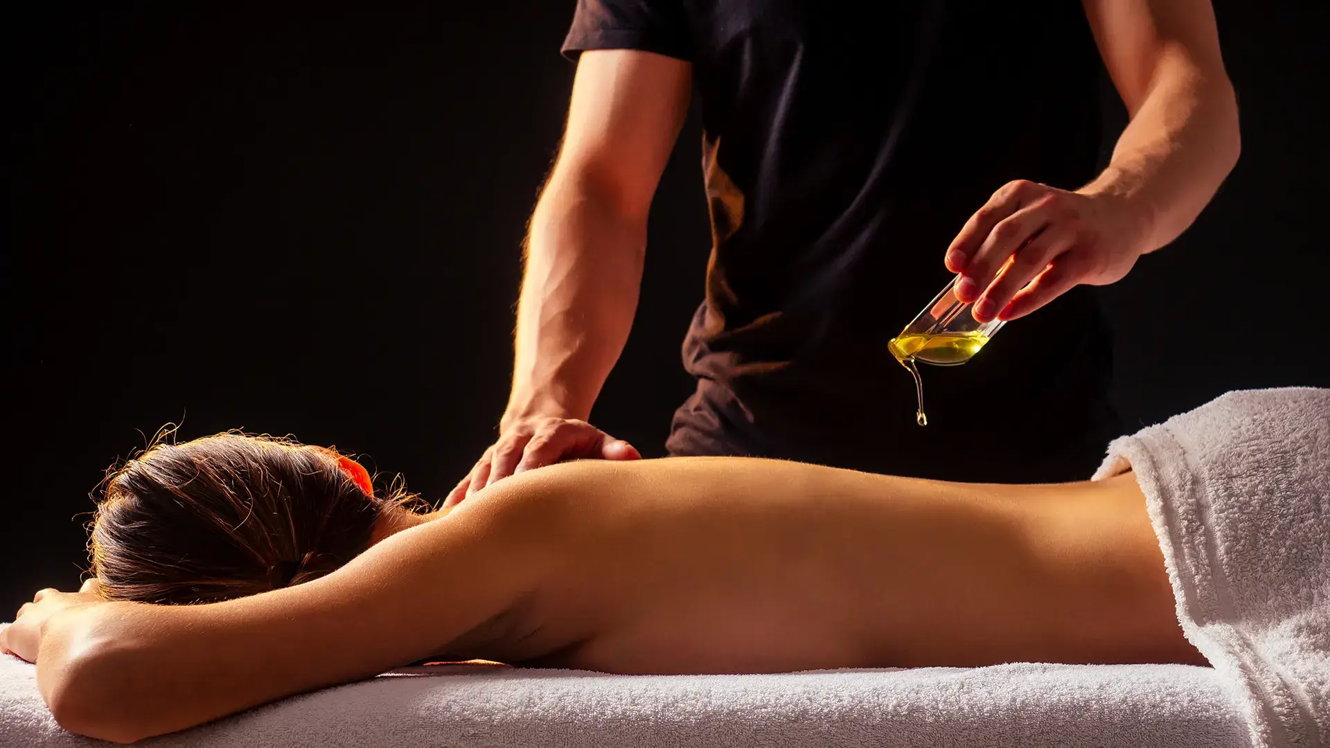 Une goutte d’huile de massage tombe sur le dos
